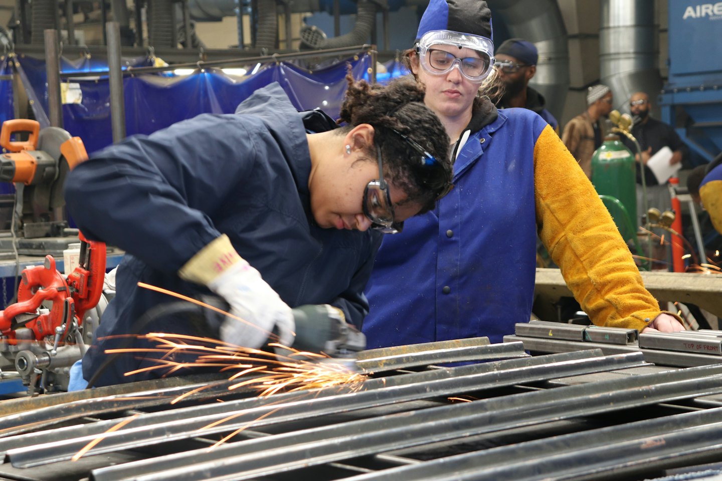 Donne con dispositivi di sicurezza che usano attrezzi in un'officina.